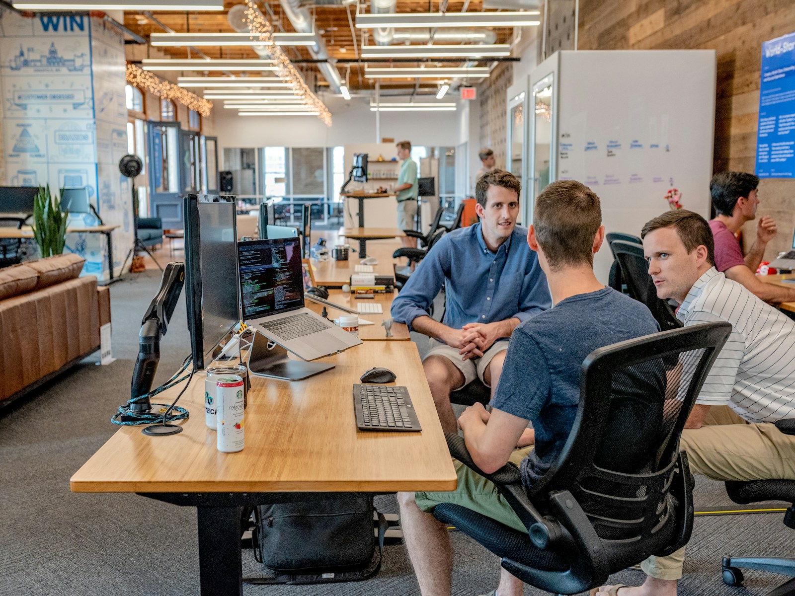 Team collaborating around laptops in a bright office